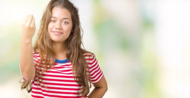 El ve parmak ile İtalyan jest yapıyor emin ifade izole arka plan üzerinde tişört giyen genç güzel esmer kadın çizgili