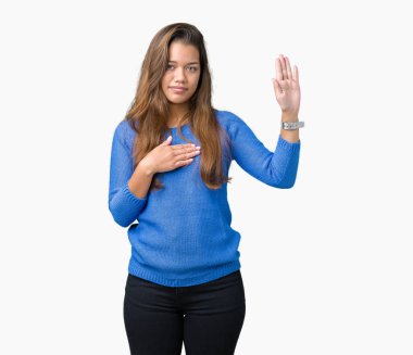 Üzerinde mavi kazak giyen genç güzel esmer kadın izole arka plan göğüs ve bir sadakat sözü yemin yapma avuç, el ile küfür