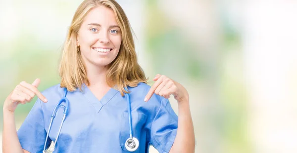 美丽的年轻医生妇女穿着医疗制服在孤立的背景看起来自信与微笑在脸上 用手指指向自己骄傲和快乐 — 图库照片
