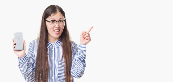 若い中国の女性を分離背景表示壊れたスマート フォン画面側を手と指で指している非常に満足 — ストック写真