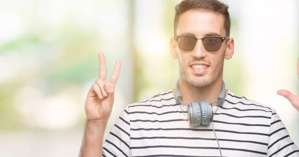 Schöner Junger Mann Mit Kopfhörer Der Mit Finger Nummer Sieben — Stockfoto