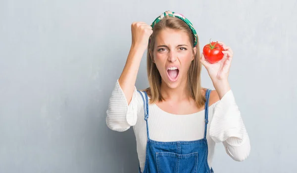 Belle Jeune Femme Sur Mur Gris Grunge Mangeant Tomate Fraîche — Photo