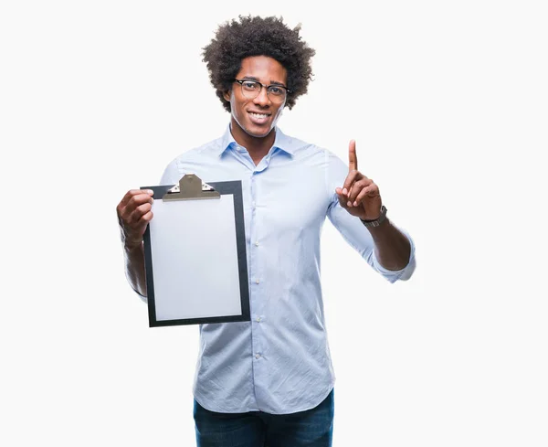 Afro Americano Segurando Prancheta Sobre Fundo Isolado Surpreso Com Uma — Fotografia de Stock