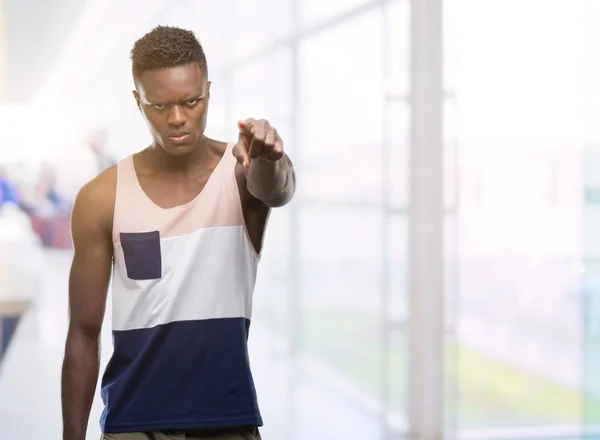 Young african american man pointing with finger to the camera and to you, hand sign, positive and confident gesture from the front