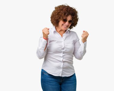 Gülümseyen ve başarı için çığlık izole arka plan çok mutlu ve heyecanlı kaldırdı, silah ile kazanan jest yapıyor üzerinde güneş gözlüğü takıyor güzel orta ager üst düzey bir iş kadını. Kutlama kavramı.