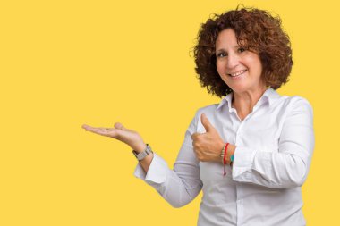 İzole arka plan gösteren palm el ve yukarıya, mutlu ve neşeli gülümseyen baş parmakları Tamam jest yapıyor güzel orta ager üst düzey businees kadın