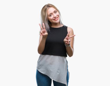 Genç Sarışın kadın parmaklarını zafer işareti yaparken gösterilen kamera seyir gülümseyen izole arka plan yüzünden. İki numaralı.