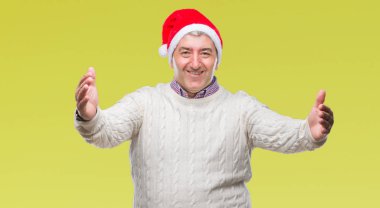 Yakışıklı komuta sizde sarılmak için kollarını açarak gülümseyerek kameraya bakarak izole arka plan üzerinde Noel şapka giyiyor. Neşeli ifade kucaklayan mutluluk.