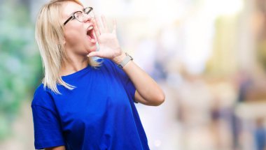 Bağırarak ve ağzı üzerinde el ile yan için çığlık izole arka plan üzerinde gözlük takan genç güzel sarışın bir kadın. İletişim kavramı.