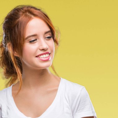 Genç güzel kadın uzak tarafına yüzünde, doğal ifade gülümseme ile seyir izole arka plan yüzünden. Kendine güvenen gülüyor.