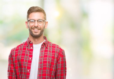 Yakışıklı delikanlı uzak tarafına yüzünde, doğal ifade gülümseme ile seyir izole arka plan üzerinde. Kendine güvenen gülüyor.