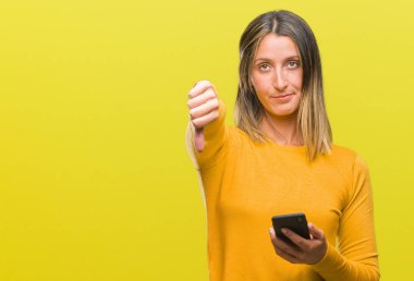 Kızgın yüz, eksi işareti aşağı antipati başparmak ile gösterilen, ret kavramı ile izole arka plan üzerinde Smartphone kullanarak ileti gönderme genç güzel kadın