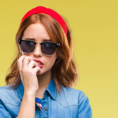 Genç güzel kadın yüzünden stresli ve gergin ile eller tırnak ısırma dudaklarından seyir güneş gözlüğü takıyor izole arka plan. Anksiyete sorunu.