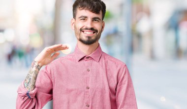 Büyük ve büyük boy işaret, ölçü birimi sembol gösteren ellerle eller izole arka plan üzerinde pembe gömlek giymiş yakışıklı delikanlı. Kameraya bakarak gülümsüyordu. Ölçüm kavramı.