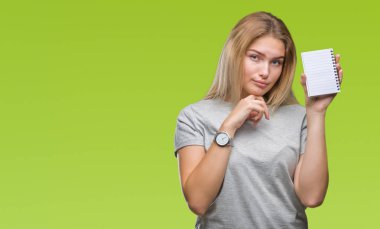 İzole arka plan ciddi bir yüz düşünme hakkında soru, çok karışık bir fikir üzerinde boş defter tutan genç beyaz kadın