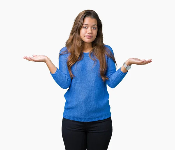 上青いセーターを着ている若い美しいブルネットの女性は 腕と手を上げて背景無知と混乱式を分離しました 疑いのコンセプト — ストック写真