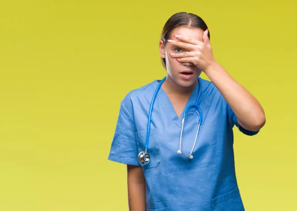 Joven Doctora Caucásica Vistiendo Uniforme Médico Sobre Fondo Aislado Asomándose —  Fotos de Stock