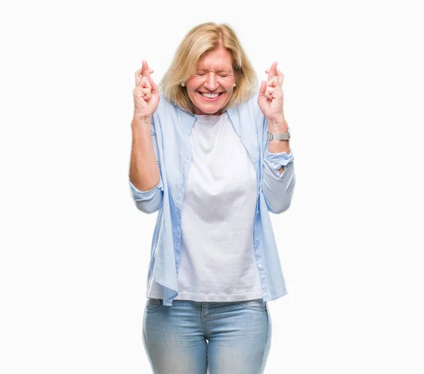 Mulher Loira Meia Idade Sobre Fundo Isolado Sorrindo Cruzando Dedos — Fotografia de Stock