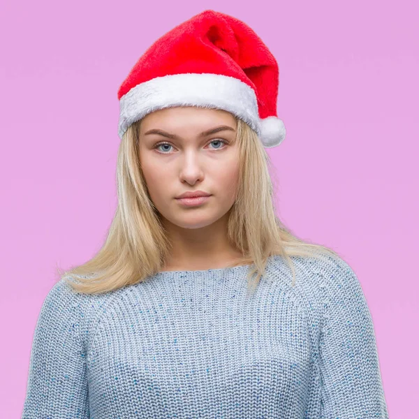 若い白人女性の顔に真剣な表情で孤立した背景にクリスマス帽子をかぶっています シンプルで自然なカメラを見てください — ストック写真