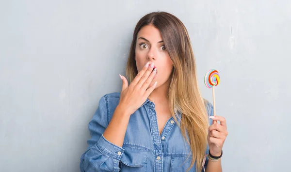 Joven Mujer Adulta Sobre Gris Grunge Pared Comer Caramelo Lollipop — Foto de Stock