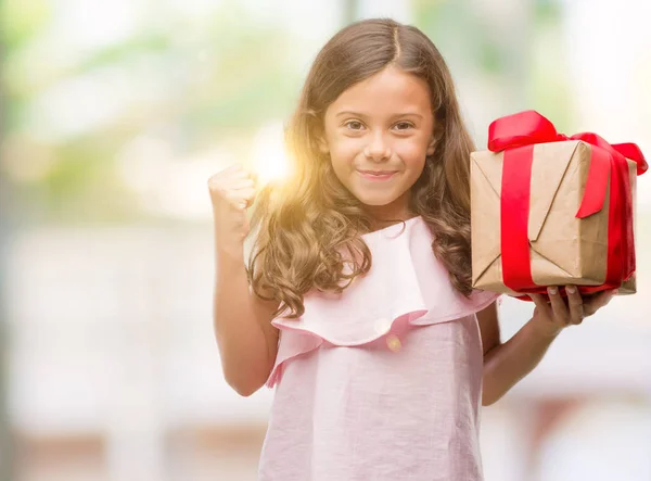 Morena Hispânica Menina Segurando Presente Gritando Orgulhoso Celebrando Vitória Sucesso — Fotografia de Stock