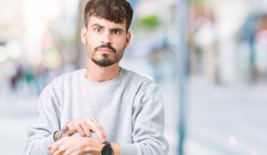 Acele işaretleme izlemek için zaman, sabırsızlık, üzgün ve kızgın son tarih gecikme için izole arka plan üzerinde sweatshirt giyen genç yakışıklı adam