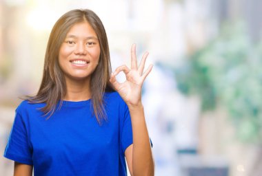 Gülümseyen izole arka plan üzerinde Genç Asyalı kadın el ve parmaklar ok işaretiyle yapıyor olumlu. Başarılı ifade.