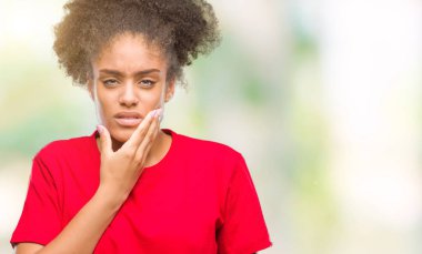 Diş ağrısı veya dişlerde dişlerle ilgili hastalık nedeniyle ağız acı ifadesi ile el ile dokunmak izole arka plan üzerinde genç afro Amerikalı kadın. Diş hekimi kavramı.