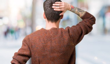 İzole arka plan geriye düşünme hakkında şüphe ile baş taraftan üzerinde kış kazak giyen genç yakışıklı adam