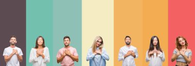 Göğüs kapalı gözler ve yüzünde minnettar jest ile kolaj farklı etnik gençlerin ile gülümseyen izole renkli çizgili arka plan üzerinde eller. Sağlık kavramı.