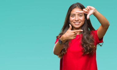 Genç güzel Arap kadın elle yapma çerçeve ve parmakları ile mutlu yüz gülümseyen izole arka plan yüzünden. Yaratıcılık ve Fotoğrafçılık kavramı.