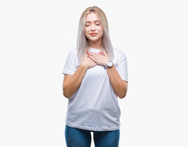 Sarışın genç kadın ile gülümseyen izole arka plan üzerinde kapalı gözler ve yüzünde minnettar jest ile göğüs üzerinde eller. Sağlık kavramı.