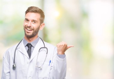 Genç yakışıklı Doktor adam arıyor ve başparmak yanında yukarıyı mutlu yüz ile gülümseyen izole arka plan.