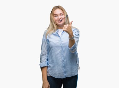 Genç beyaz iş kadın giyiyor çağrı merkezi kulaklık hareketi el ile mutlu yaşasın yapıyor izole arka plan üzerinde. Kameraya bakarak başarı gösteren ile ifade onaylama.