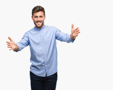 Yakışıklı delikanlı sarılmak için kollarını açarak gülümseyerek kameraya bakarak izole arka plan üzerinde. Neşeli ifade kucaklayan mutluluk.