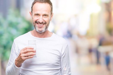 Orta yaş ağarmış komuta sizde ayakta ve diş gösterilen kendine güvenen bir gülümsemeyle gülümseyerek mutlu bir yüz ile izole arka plan üzerinde bardak su içme