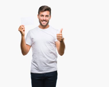 Yakışıklı delikanlı izole arka plan üzerinde boş kartı ok işareti, başparmak ile parmak, mükemmel işareti yapıyor kocaman bir gülümseme ile mutlu holding