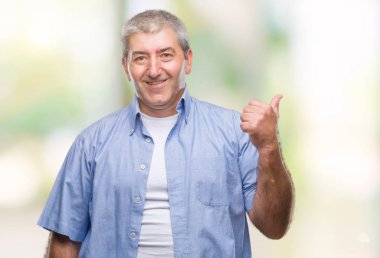 Seyir ve başparmak yanında yukarıyı mutlu yüz ile gülümseyen izole arka plan üzerinde üst düzey yakışıklı.