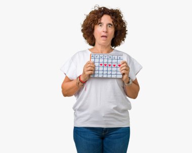 Adet takvim izole arka plan üzerinde bir sürpriz yüz, korkuyor ve heyecanlı korku ifadesi ile şok korkmuş tutan orta ager üst düzey kadın