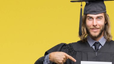 Genç yakışıklı adam mezun sürpriz yüz işaret parmağı kendini izole arka plan üzerinde boş kağıt tutan uzun saçlı