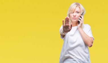Arama ve smartphone ile izole arka plan üzerinde konuşmak genç güzel sarışın kadın dur işareti ile ciddi ve kendine güvenen ifade, savunma hareketi yaparken el açmak