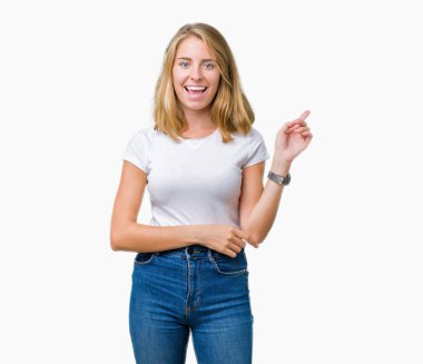 Kameraya bakarak yan el ve parmak ile işaret yüzünde kocaman bir gülümseme ile izole arka plan üzerinde rahat beyaz t-shirt giyen güzel genç kadın.