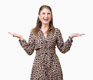 Gülen iki elle gösterilen açık avuç içi, sunma ve karşılaştırma ve denge reklam arka plan üzerinde leopar elbise giyen güzel orta yaş olgun zengin kadın izole