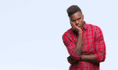 İzole arka plan düşünme seyir üzerinde genç Afro-Amerikan adam yorgun ve sıkılmış çapraz silah depresyon sorunları ile.