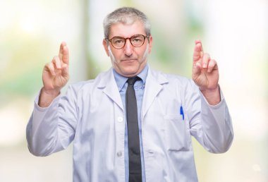 Yakışıklı kıdemli Doktor, umut ve gözleri kapalı geçiş parmaklarıyla gülümseyen arka plan üzerinde beyaz önlük giyen bilim adamı profesyonel adam izole. Şans ve batıl kavramı.