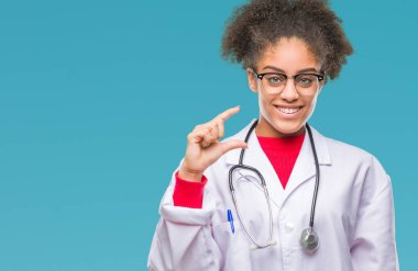 Genç afro Amerikalı doktor kadın izole arka plan gülümseyen ve boyutu işaret parmaklı ararken ve kamera işi el ile kendine güvenen el hareketi yüzünden. Ölçü kavramı.