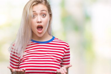 Genç Sarışın kadın izole arka plan korkuyor ve sürpriz ifade ile şok yüzünden korku ve yüz heyecanlı.