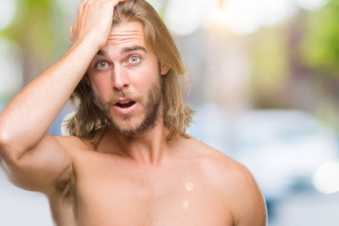 Young handsome shirtless man with long hair showing sexy body over isolated background surprised with hand on head for mistake, remember error. Forgot, bad memory concept. clipart