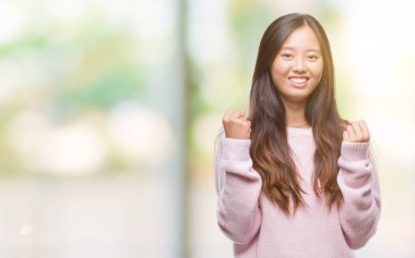 Gülümseyen ve başarı için çığlık Genç Asyalı kadın izole arka plan çok mutlu ve heyecanlı kaldırdı, silah ile kazanan jest yapıyor. Kutlama kavramı.