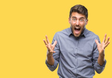 Yakışıklı delikanlı deli kutluyor ve silah ile başarı için heyecanlı çığlık kaldırdı ve açık gözleri hayret izole arka plan üzerinde. Kazanan kavramı